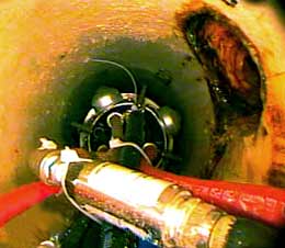 grout packer being positioned to seal a service connection